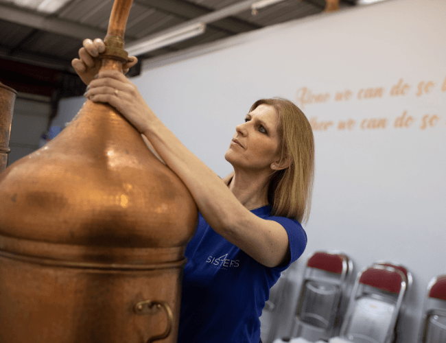 Image of a lady touching a gin still